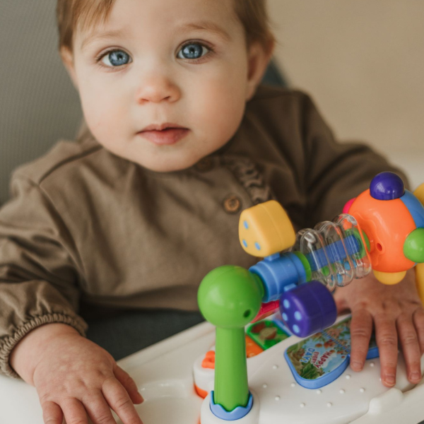 Baby exercising legs in grow-with-baby bouncer seat
